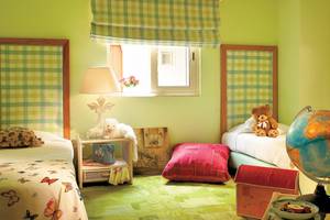 Zwei Kinderzimmer mit grünen Wänden, Betten, Kissen, Lampen, Spielzeug und einem Globus.