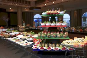 Buffet-Tisch im Wyndham Garden Salalah Mirbat mit verschiedenen Gerichten auf mehreren Etagen.