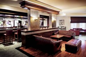 Hotellounge des Wyndham Garden Salalah Mirbat mit Bar, Sesseln und Tischen.