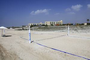 Ein Volleyballnetz auf dem Strand im Wyndham Garden Salalah Mirbat.