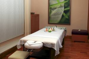 Massage-Behandlungsraum im Wyndham Garden Salalah Mirbat mit einem Bett, Kissen und einer weißen Decke.