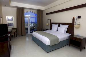 Hotelzimmer mit einem Bett, einem Balkon und Meerblick im Wyndham Garden Salalah Mirbat