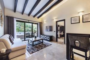 Wohnbereich im Grand Palladium Kantenah Resort mit Sofa, Tisch und Fernseher.