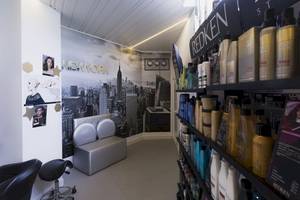 Salon mit New York Wandbild und Haarpflegeprodukten auf Regalen.