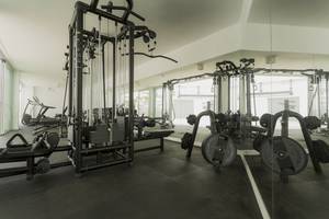 Innenansicht des Fitnesscenters im Caserio Hotel mit verschiedenen Trainingsgeräten und Geräten.