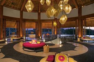 Innenraum des Hotel-Lobby-Bereichs von Secrets Akumal Riviera Maya mit Loungemöbeln, Beleuchtung und Aussicht.