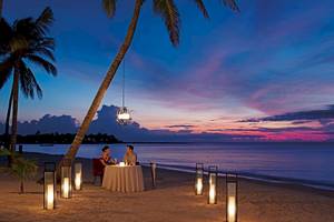 Paar genießt ein Abendessen am Strand im Secrets Akumal Riviera Maya.