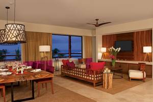 Wohnzimmer im Secrets Akumal Riviera Maya mit Blick auf das Meer, Tisch und Sofa.