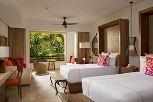Suite im Secrets Akumal Riviera Maya Hotel mit zwei Betten, Balkon und tropischer Aussicht