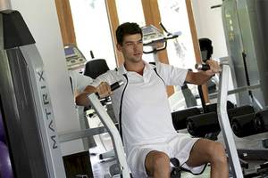 Ein Mann trainiert im Fitnessstudio des Holiday Inn Mai Khao Resort.