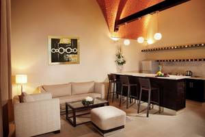 Wohnbereich im Cove Rotana Resort mit Couch, Tisch und Bar.