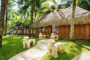 Kinderbereich im The Reef Coco Beach Hotel mit Spielhaus, Rutsche und hügeligen Pfaden.