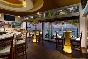Innenansicht der Bar im The Reef Coco Beach Hotel mit Blick auf das Meer
