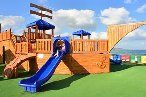 Spielplatz im Kiani Beach Resort mit Piratenschiff und Rutsche am Meer