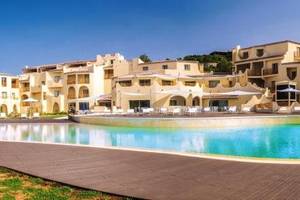 Außenbereich des Cala Cuncheddi Hotels mit großem Pool und vielen Sonnenliegen.