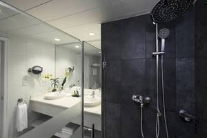 Badezimmer im Ocean Blue & Sand by H10 Hotel mit Dusche und zwei Waschbecken.