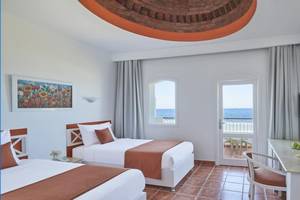 Hotelzimmer mit zwei Betten, Blick auf das Meer und Balkon.