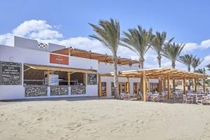 Strandrestaurant des JAZ Neo Reef Marsa Alam Hotels mit Palmen und Tischen im Freien