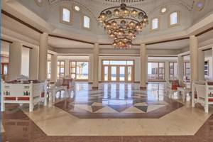 Lobby des JAZ Neo Reef Marsa Almaz Hotel mit weißen Möbeln und einem großen Kronleuchter