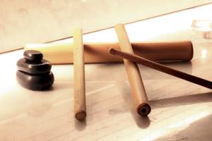 Ein Foto von drei Bambusstäben und zwei Steinen auf einer Marmorplatte.