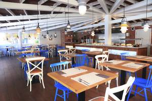 Innenansicht des Restaurants im O7 Aloe Corralejo Hotel mit blauen Stühlen und Holztischen.
