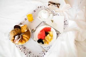 Frühstücksbuffet im Torre del Mar Hotel mit Croissants, Früchten und einem Glas Orangensaft.