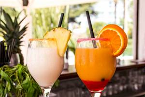 Zwei Cocktails auf einer Bar im Hotel Torre del Mar, mit Früchten und Strohhalmen.