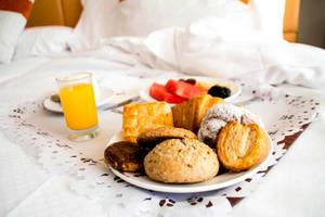 Frühstücksbuffet im Torre del Mar Hotel mit verschiedenen Gebäck, Früchten und einem Glas Orangensaft.