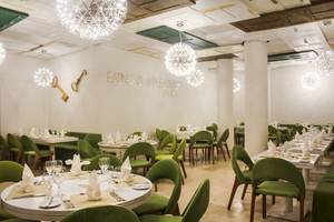 Speisesaal des Viva Tangerine by Wyndham Hotels mit grünen Stühlen und Tischdecken.