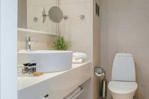Badezimmer im Nissi Beach Resort mit weißem Waschbecken, Toilette und Badewanne.
