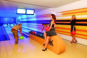 Royal Dragon Hotel Bowlinghalle mit bunten Wänden und Spielenden.
