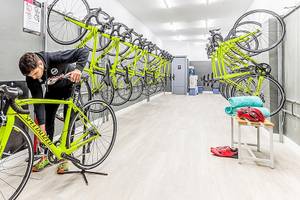 Mann, der ein Fahrrad in einer Fahrradwerkstatt des Viva Golf Adults Only Hotels repariert