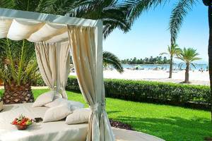 Viva Golf Adults Only Hotel Strandbett mit Baldachin auf dem Rasen neben einem Palmenbaum.