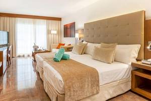 Hotelzimmer im VIVA Golf Adults Only Hotel mit Doppelbett, Dekor und Fenstern.