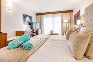 Doppelbettzimmer im Viva Golf Adults Only Hotel mit Fernseher und Schreibtisch.