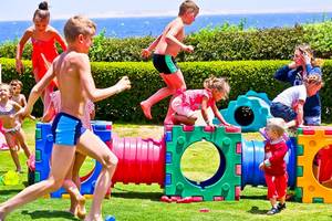 Kinder spielen in einem Freizeitpark mit bunten Spielgeräten.