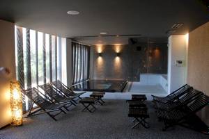 Innenbereich des Doryssa Seaside Resort mit Lounge-Stuhlreihen und Whirlpool.