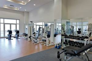 Fitnessstudio im Selectum Colours Bodrum Hotel mit vielen Geräten und großen Fenstern.