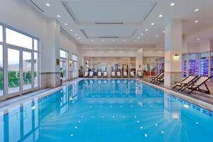 Innenpool des Selectum Colours Bodrum Hotels mit Liegestühlen und Glaswänden