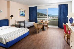 Innenansicht eines Zimmers im Dionysos Hotel mit Blick auf einen Balkon.