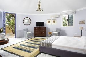 Schlafzimmer im Dionysos Hotel mit einem Bett, zwei Stühlen, einem Tisch und einem Fernseher