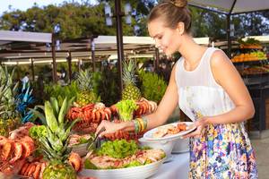 Frau am Buffet im Marti Myra Hotel, serviert Hummer und Shrimps.