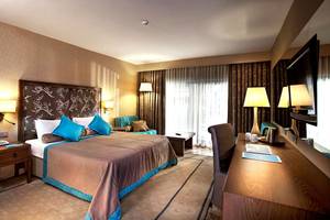 Ein elegantes Hotelzimmer im Marti Myra Hotel mit Doppelbett, Nachttischen, Schreibtisch und Fernseher.