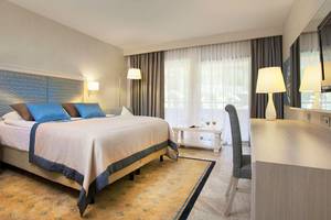 Schlafzimmer im Marti Myra Hotel mit einem großen Bett, Kissen und einem Schreibtisch.