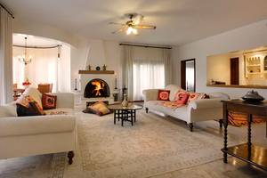 Wohnzimmer im Marti Myra Hotel mit zwei weißen Sofas, einem Kamin und einem Teppich.