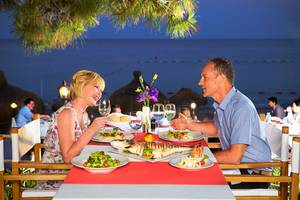 Paar genießt ein Abendessen im Garten des Hotels Marti Myra mit Blick auf das Meer.