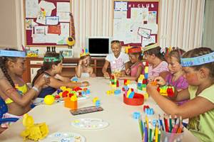 Kinder basteln im Titan Select Hotel mit bunten Farben und Spielzeug.