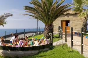 Gruppe von Kindern spielt im Sandkasten am Strand vor dem H10 Rubicon Palace