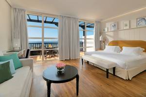 Schlafzimmer im H10 Rubicon Palace Hotel mit Blick auf den Balkon.