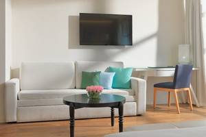 Wohnzimmer im H10 Rubicon Palace mit Sofa, Tisch, Fernseher und Stuhl.